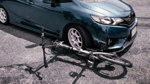 a damaged bike underneath a car