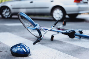 a damaged bike with a bicycle helmet on the ground